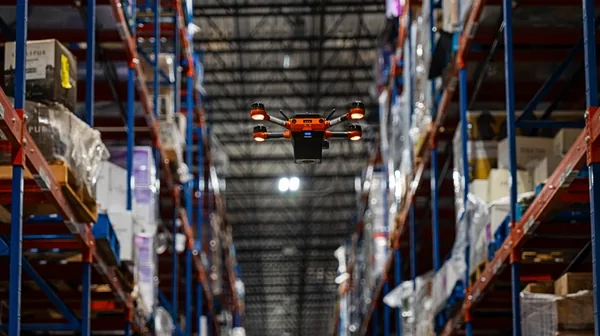 A Corvus One autonomous inventory drone scans warehouse racking at Southern Glazer's Wine & Spirits distribution center, capturing real-time inventory data in a high-bay reserve storage environment