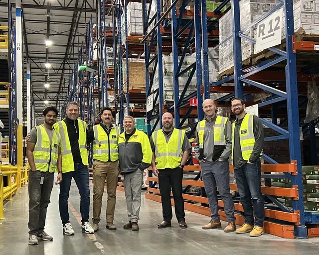 Members of the Corvus Robotics and Southern Glazer's Wine & Spirits teams in front of high-bay racking and a Corvus One landing pad at Southern Glazer's Raymore, MO distribution center